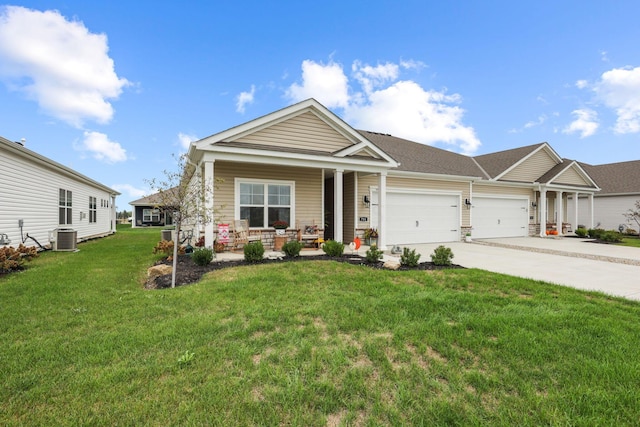 craftsman house featuring central air condition unit, covered porch, a front yard, and a garage