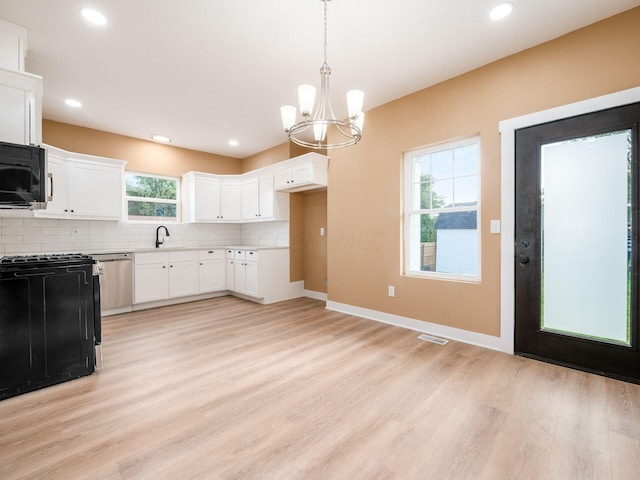 kitchen with sink, hanging light fixtures, light hardwood / wood-style floors, white cabinets, and black appliances