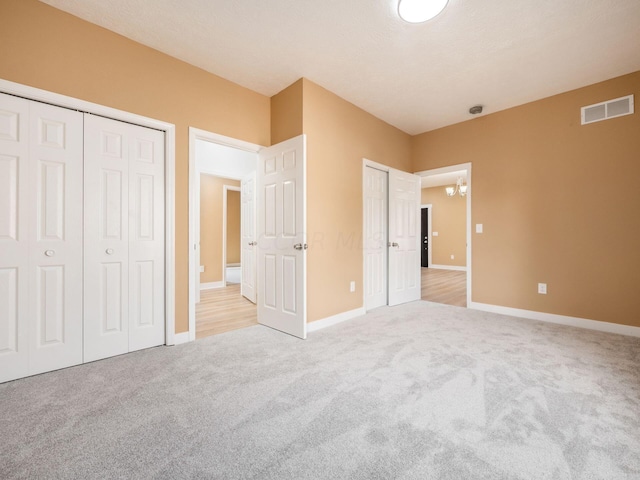 unfurnished bedroom featuring light carpet