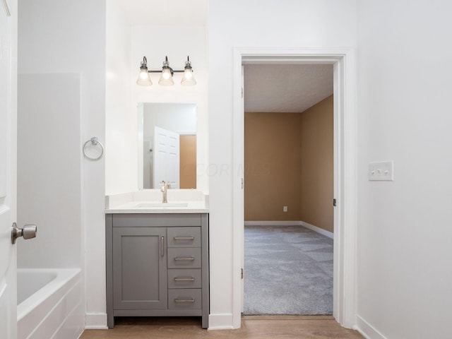 bathroom featuring a bathing tub, vanity, and hardwood / wood-style flooring