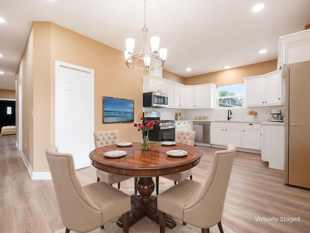 dining space with a chandelier, light hardwood / wood-style flooring, and sink