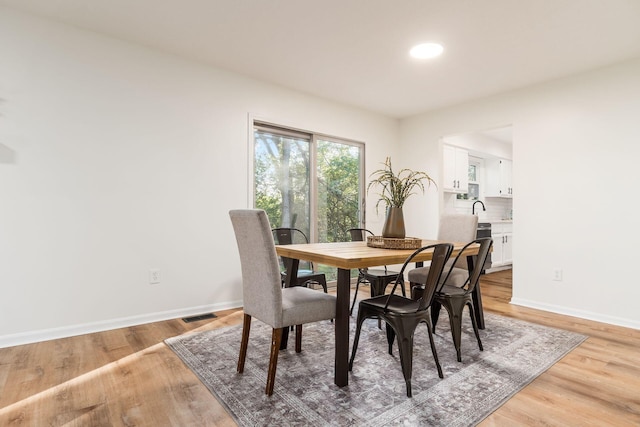 dining room with sink and light wood-type flooring