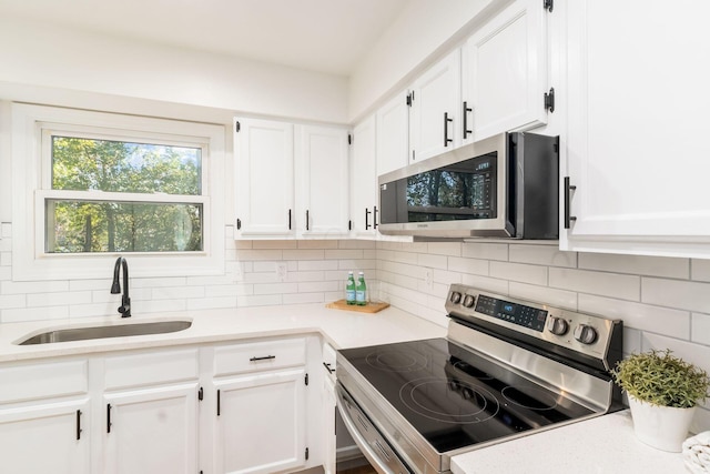 kitchen with sink, white cabinetry, stainless steel appliances, and tasteful backsplash