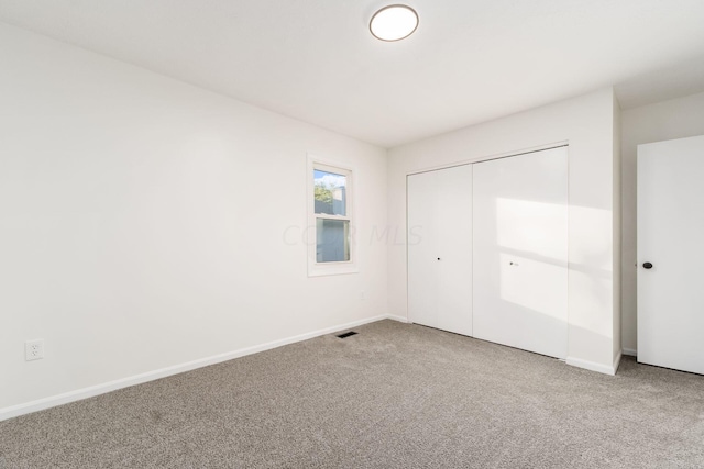 unfurnished bedroom with carpet flooring and a closet