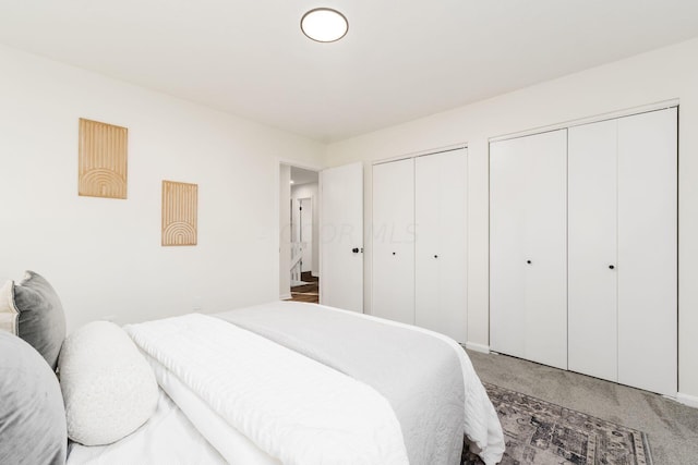 bedroom featuring carpet floors and multiple closets