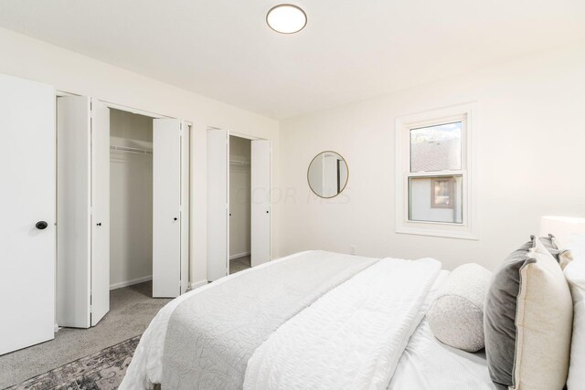 bedroom featuring multiple closets and carpet