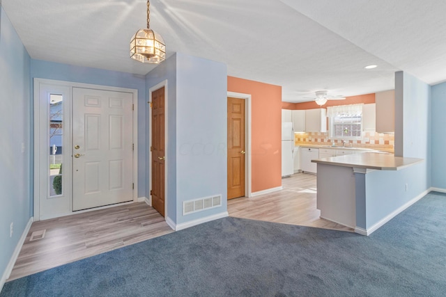 foyer featuring ceiling fan, sink, and light hardwood / wood-style flooring