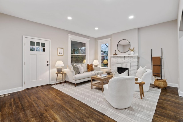 living room with dark hardwood / wood-style floors and a fireplace