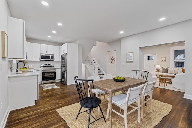 dining space featuring sink and dark wood-type flooring