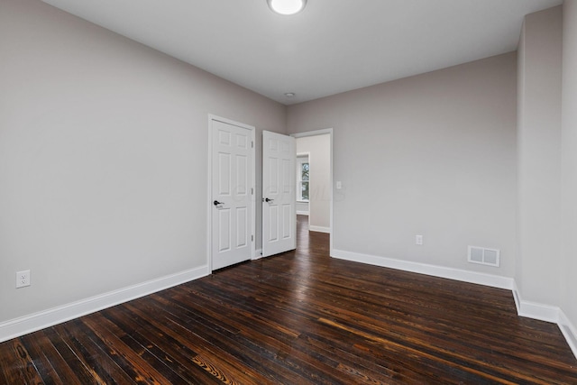 unfurnished room with dark hardwood / wood-style flooring