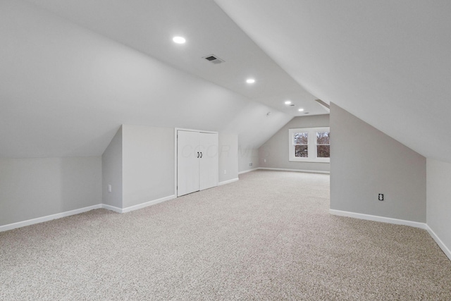 bonus room featuring vaulted ceiling and carpet