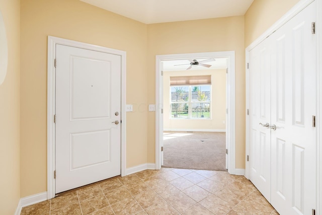 interior space featuring ceiling fan and light colored carpet