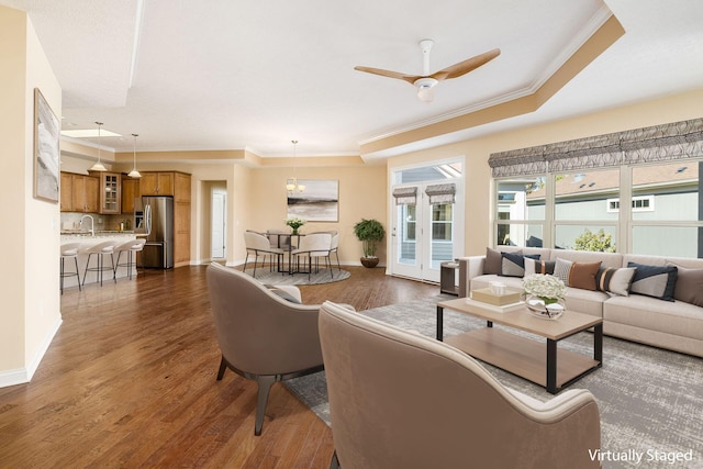 living room with sink, crown molding, dark hardwood / wood-style floors, ceiling fan, and a tray ceiling