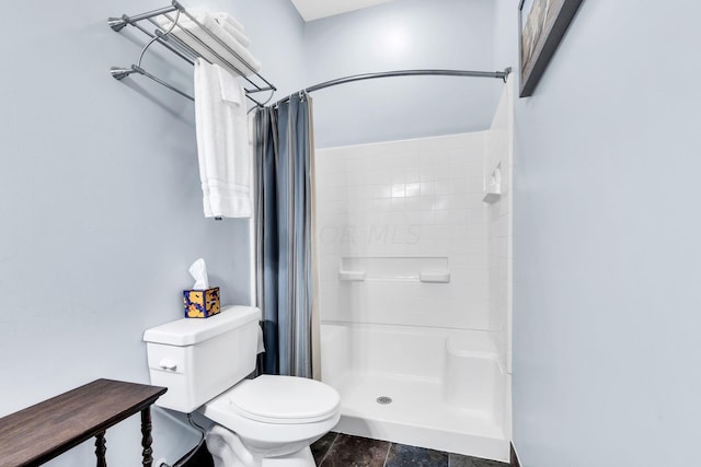 bathroom with a shower with shower curtain and toilet