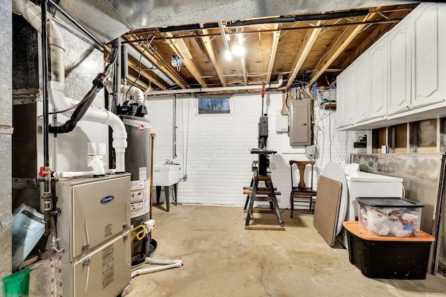 basement with brick wall, sink, electric panel, and water heater