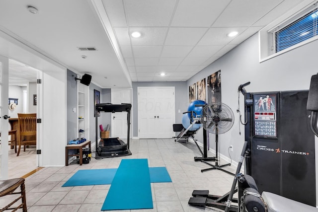 workout room featuring a drop ceiling and light tile patterned floors