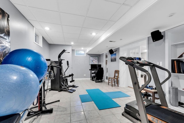 exercise room featuring a drop ceiling and light tile patterned flooring