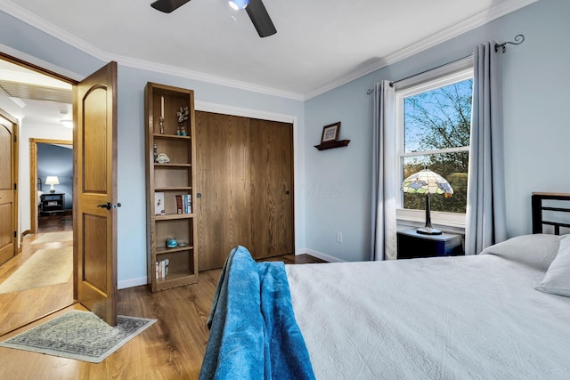 bedroom featuring ceiling fan, a closet, dark hardwood / wood-style floors, and ornamental molding