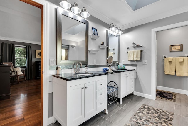 bathroom featuring hardwood / wood-style floors, vanity, crown molding, and a notable chandelier