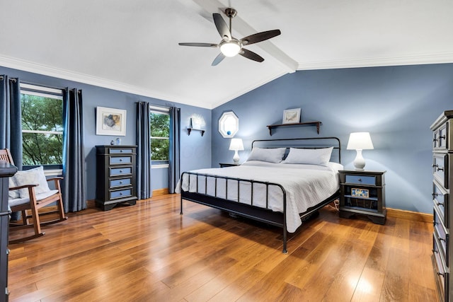 bedroom featuring vaulted ceiling with beams, ceiling fan, crown molding, and hardwood / wood-style flooring