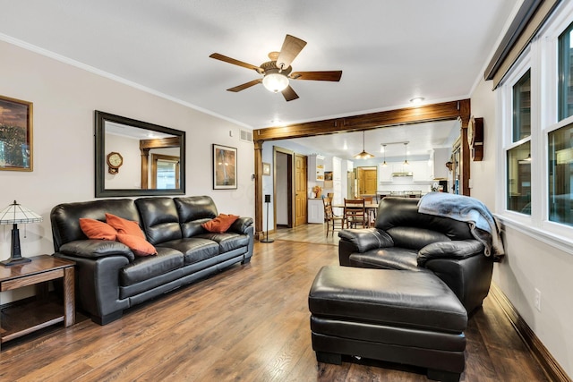 living room with hardwood / wood-style flooring, ceiling fan, and ornamental molding