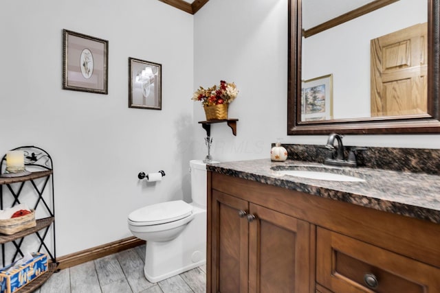 bathroom featuring wood-type flooring, vanity, toilet, and ornamental molding