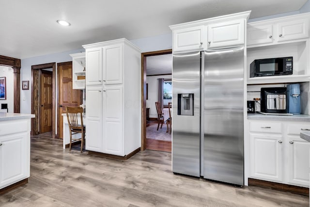 kitchen with light hardwood / wood-style floors, stainless steel fridge, and white cabinetry