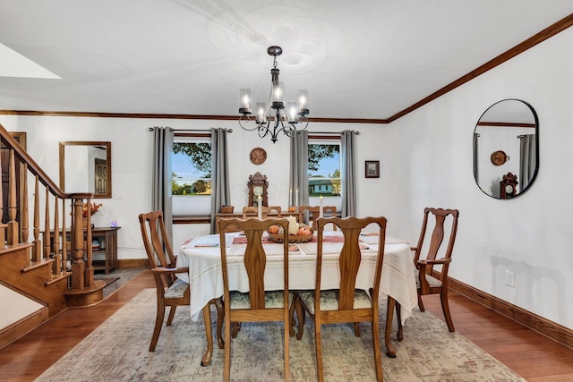 dining space featuring hardwood / wood-style flooring, a healthy amount of sunlight, and an inviting chandelier