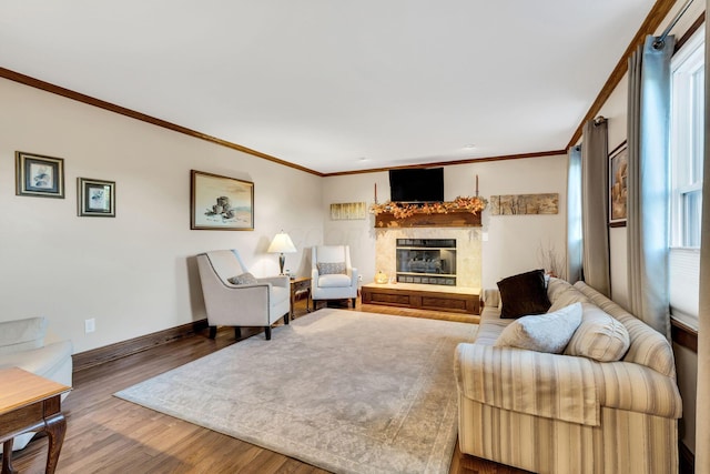 living room featuring hardwood / wood-style floors, ornamental molding, and a tiled fireplace