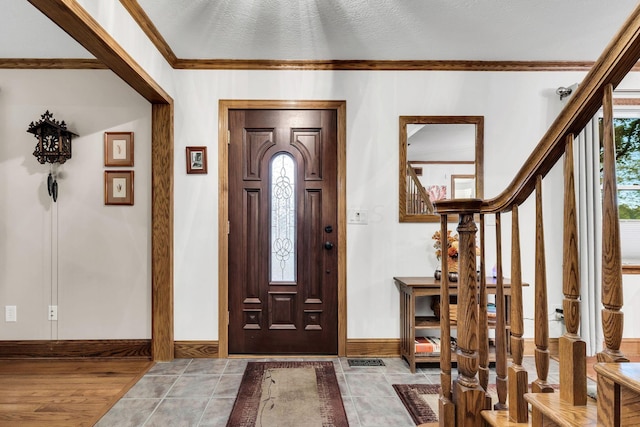 foyer featuring hardwood / wood-style flooring, crown molding, and a textured ceiling