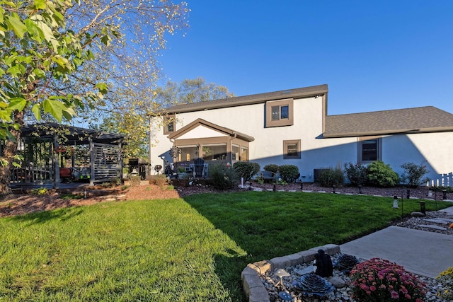 back of property with a yard and a pergola