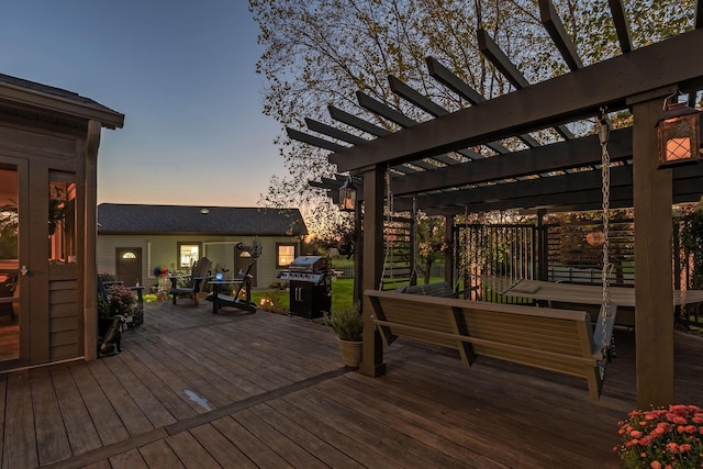 deck at dusk with a pergola and grilling area