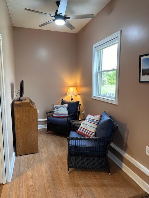 sitting room with light wood-type flooring and ceiling fan