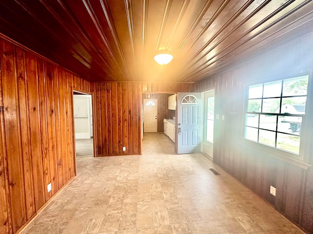 unfurnished room with wooden walls and wood ceiling