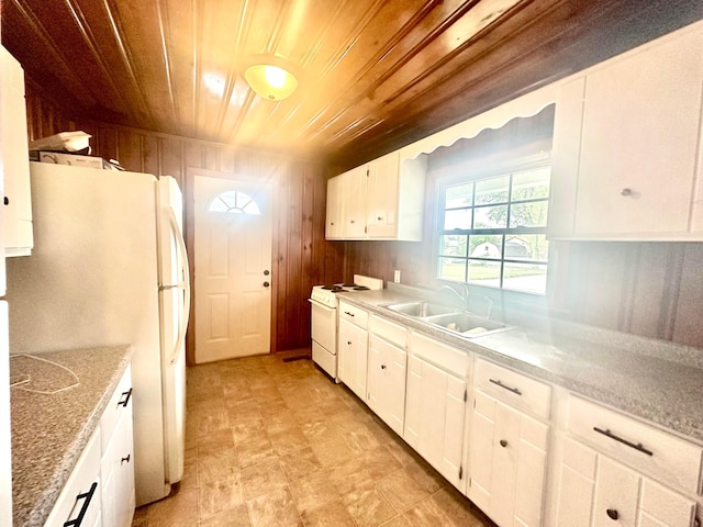 kitchen featuring white appliances, white cabinets, sink, wooden walls, and wood ceiling