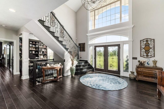 foyer with a notable chandelier, dark hardwood / wood-style floors, and french doors