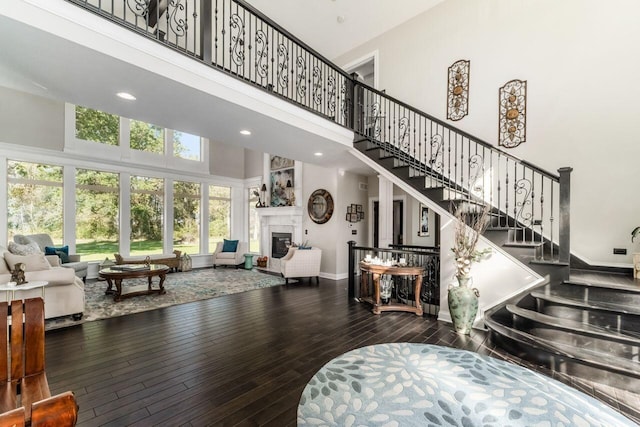 living room with wood-type flooring and a towering ceiling