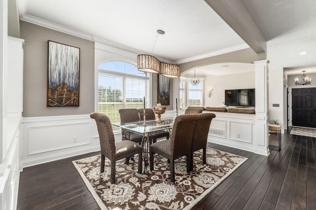 dining room featuring decorative columns, crown molding, and dark wood-type flooring