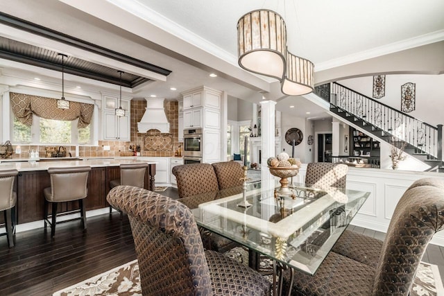 dining space with crown molding, dark wood-type flooring, and ornate columns