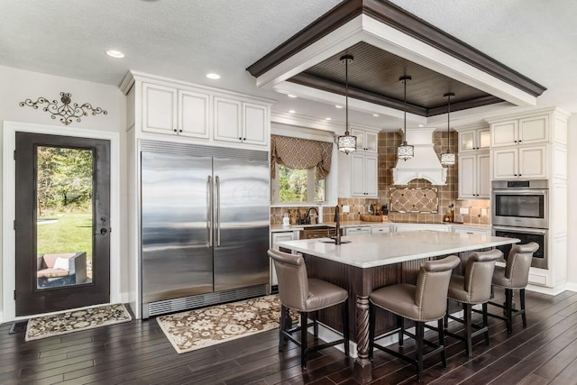 kitchen featuring pendant lighting, stainless steel appliances, plenty of natural light, and dark wood-type flooring