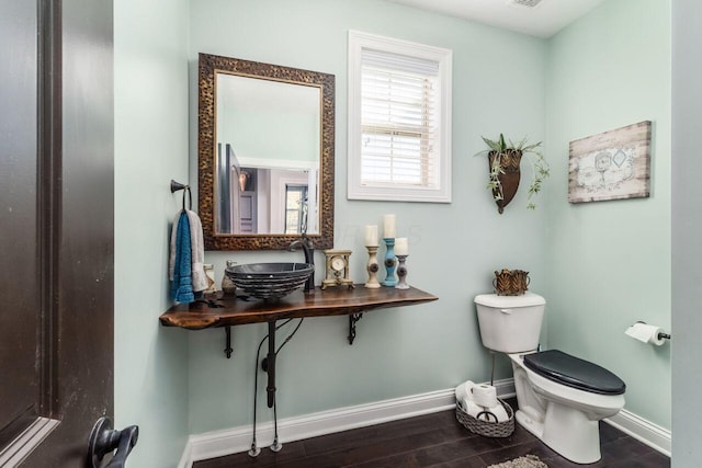 bathroom with hardwood / wood-style flooring, toilet, and sink