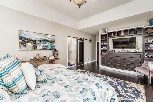 bedroom featuring a textured ceiling, a barn door, and dark hardwood / wood-style floors