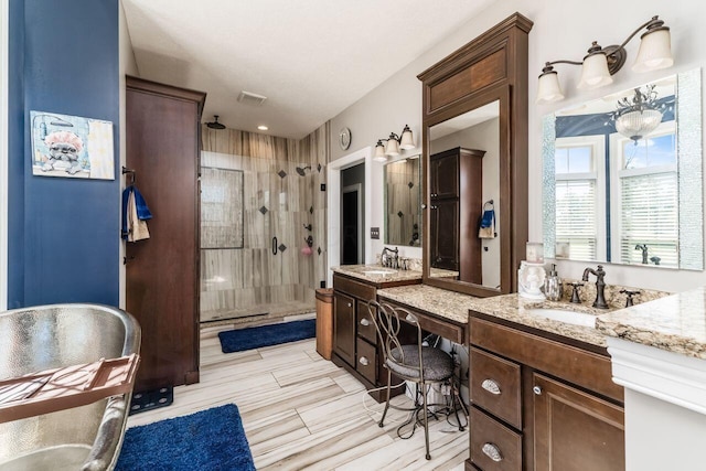 bathroom featuring a shower with door and vanity