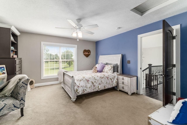 bedroom featuring carpet flooring, ceiling fan, and a textured ceiling