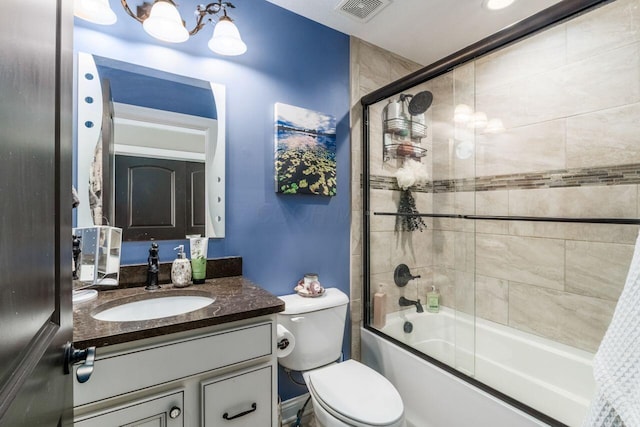 full bathroom with combined bath / shower with glass door, vanity, and toilet