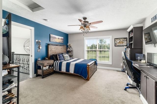 bedroom with ceiling fan, light colored carpet, and a textured ceiling