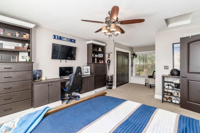 bedroom with ceiling fan, light colored carpet, and a textured ceiling