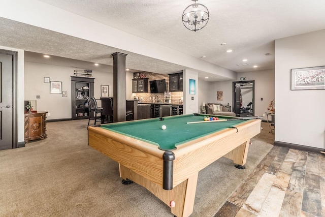 recreation room with carpet, a textured ceiling, indoor bar, and pool table