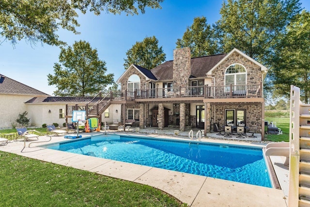 view of pool featuring a wooden deck, a water slide, and a patio