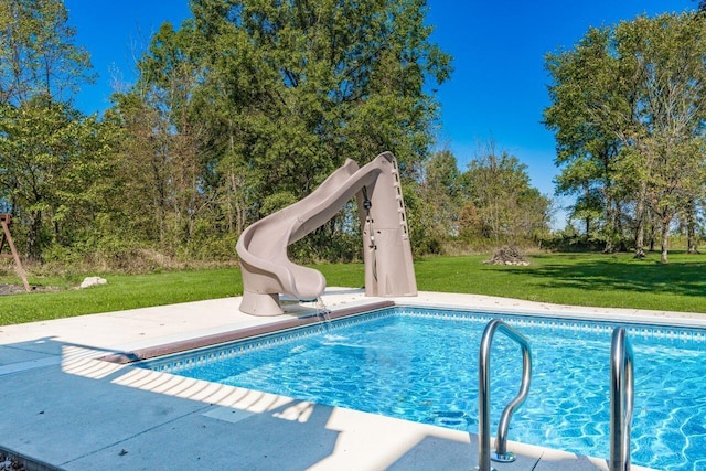 view of swimming pool with a yard, a patio, and a water slide